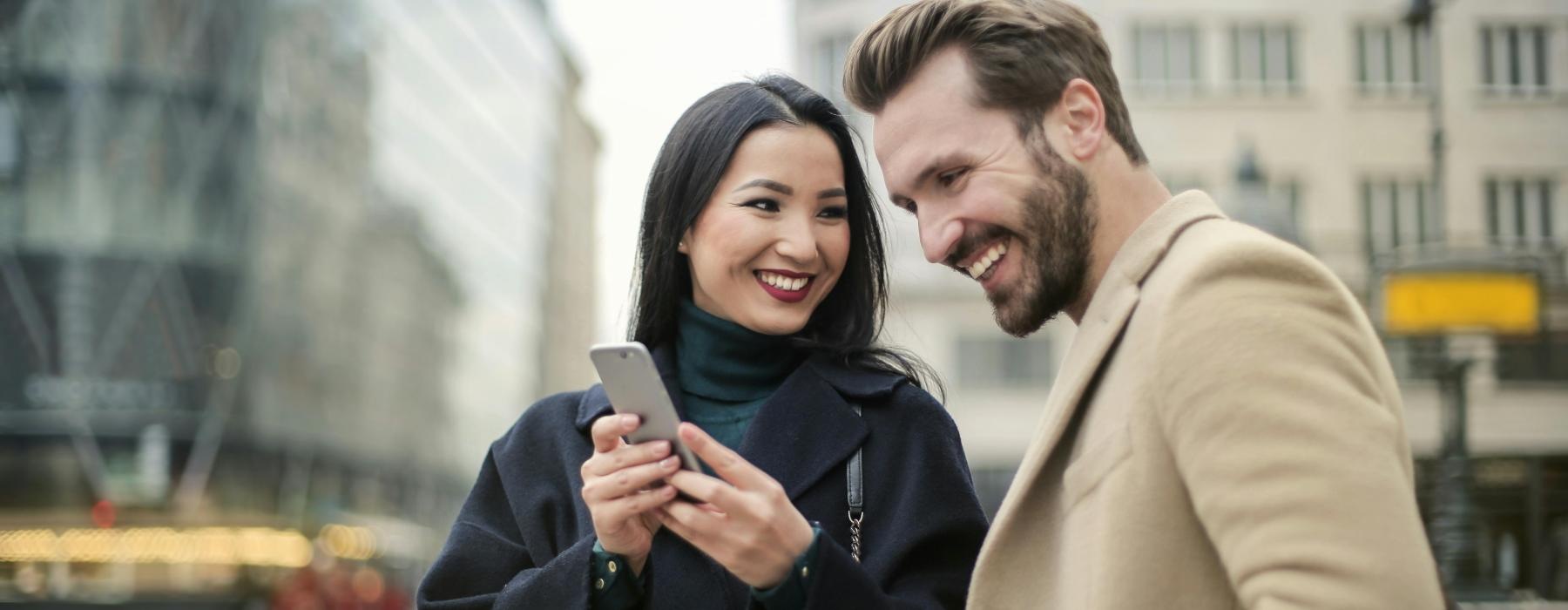 a man and woman looking at a phone