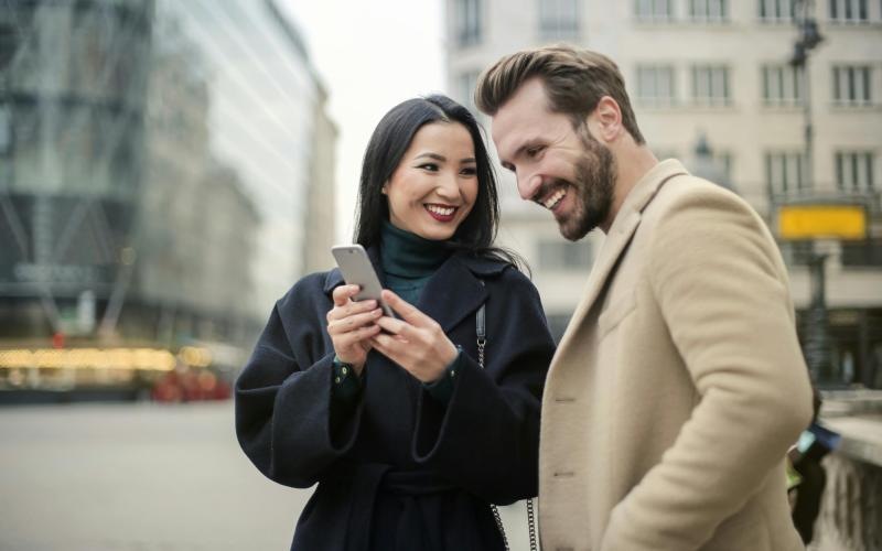 a man and woman looking at a phone